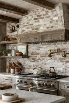 a kitchen with an oven, stove and counter top in front of a brick wall