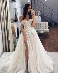 a woman is taking a selfie in her wedding dress while standing on the floor