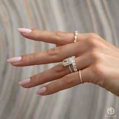 a woman's hand with two rings on her fingers and one ring in the middle