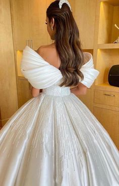 the back of a woman's wedding dress, with her hair in a ponytail