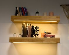 two wooden shelves with books on top of them and a toy car in the middle