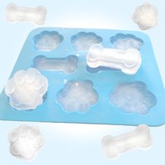 an ice tray with dog paw prints on it and four different sized plastic molds