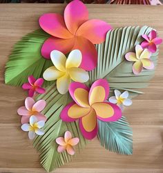 paper flowers and leaves on a wooden surface