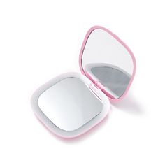 a compact mirror sitting on top of a white table next to a pink object in the shape of a heart