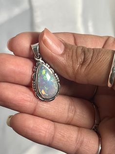 Embrace your best self with these magical Ethiopian Opal pendants. The brilliant southwest-styled setting and glowing teardrop stone make this exquisite pendant an excellent statement piece. Opals have been revered by many cultures for their unique mystical beauty and the belief that they protect against negative energy and soothe sadness. This lustrous pendant adds a touch of splendor to any outfit with its fiery hues. You won't be disappointed. Materials: .925 Sterling Silver, Ethiopian Opal A Spiritual Teardrop Pendant Large Jewelry, Spiritual Teardrop Pendant Jewelry, Teardrop Opal Gemstone Jewelry, Handmade Teardrop Opal Jewelry, Traditional Sterling Silver Teardrop Pendant Jewelry, Bohemian Teardrop Large Stone Necklace, Spiritual Teardrop Necklaces With Large Pendant, Spiritual Teardrop Necklace With Large Pendant, Spiritual Healing Teardrop Pendant Jewelry