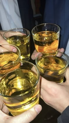 four people holding glasses filled with liquid