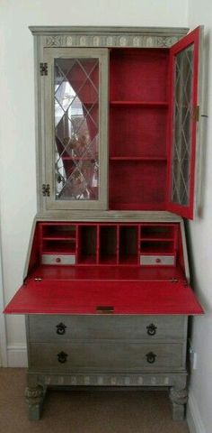 an old dresser has been painted red and silver with glass doors on the top shelf