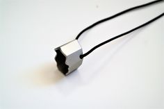 an object is shown on a white surface with a black cord attached to the end