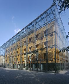 a large glass building sitting on top of a cobblestone street