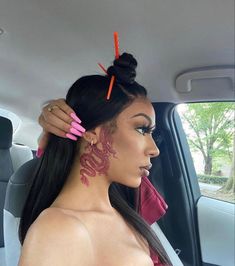 a woman sitting in the back seat of a car with tattoos on her face and neck