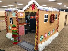 an office cubicle decorated for christmas with gingerbread house and candy canes on the door