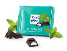 a bag of pepperminz chocolate with mint leaves around it and two pieces cut in half