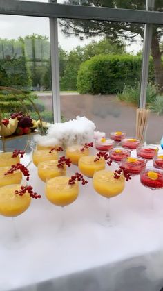 a table topped with lots of glasses filled with different types of drinks and desserts