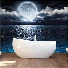 a bathtub sitting on top of a wooden floor under a full moon filled sky