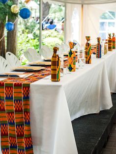 the table is set up for a party with colorful decorations and paper lanterns hanging from the ceiling