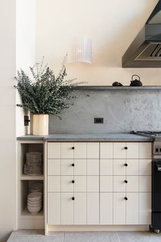 a stove top oven sitting inside of a kitchen next to a wall mounted range hood