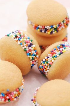 several cookies with sprinkles on top of each one sitting on a table