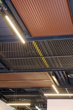 the ceiling is covered in metal mesh and yellow lines, with two lights above it