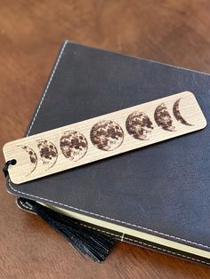 a wooden bookmark with phases of the moon on it