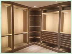 an empty walk - in closet with wooden shelves and drawers