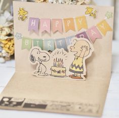 a happy birthday card with a cartoon character and a dog on the front, hanging from a string