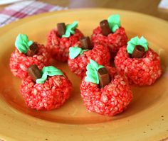 some red food on a yellow plate with green leaves and chocolate chips in the middle