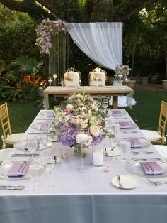 the table is set with purple and white flowers