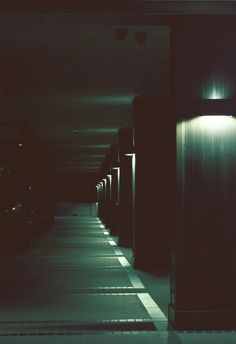 an empty hallway with several lights on either side