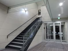 an empty hallway with stairs and glass doors