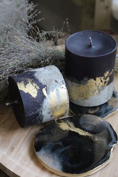 two black and gold candle holders sitting on top of a wooden table