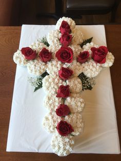 a cross made out of flowers sitting on top of a table