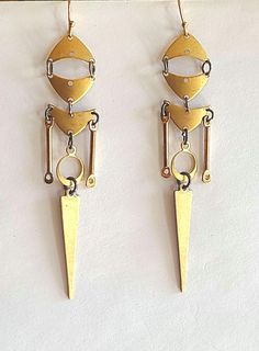 Knight earrings are made using an array of triangular, spike & circular components stitched together to form a long dangling Knightly image.  The components are made of  light weighted brass stampings that are articulated & easy to wear.  Earrings are finished with antiqued gold plated ear wires and measure 3 & 1/2 inches long & will arrive beautifully gift boxed. Geometric Metal Earrings With Ear Wire, Nickel Free Triangle Metal Earrings, Nickel-free Metal Triangle Earrings, Triangle Gold Metal Earrings, Gold Triangle Metal Earrings, Modern Triangle Metal Earrings, Geometric Brass Earrings, Earring Ideas, Earrings Geometric