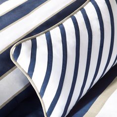 the blue and white striped bedding is neatly folded on top of it's pillow