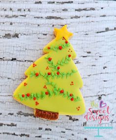 a decorated christmas tree cookie sitting on top of a table