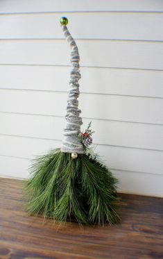 a christmas decoration made out of yarn and pine cones on top of a wooden table