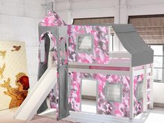 a child's bed with a pink camouflage print tent and slide next to it