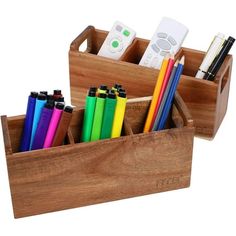 two wooden boxes with pens, pencils and remote controls in them on a white background