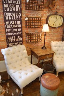 a living room with two white chairs and a clock on the wall behind them,