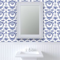 a white sink sitting under a bathroom mirror next to a wall mounted faucet