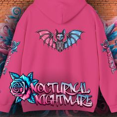 Step into the world of gothic fantasy with our "Nocturnal Nightmare" Hoodie. Featuring a striking bat-cat skeleton design with pink and blue wings, this hoodie is perfect for those who love to blend cute and macabre elements in their wardrobe. Key Features: Unique Design: Showcasing a gothic bat-cat with skeletal elements and vibrant pink and blue wings. The sleeves feature the text "Nocturnal Nightmare" with intricate rose designs, adding an extra touch of mystique. High-Quality Material: Made Gothic Sweatshirt, Bat Cat, Cat Skeleton, Skeleton Design, Birthday Gifts For Teens, Blue Wings, Cool Hoodies, Creepy Cute, Cozy Sweatshirts