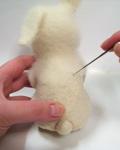 someone is cutting the end of a stuffed animal