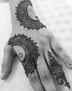 a woman's hand with henna tattoos on it