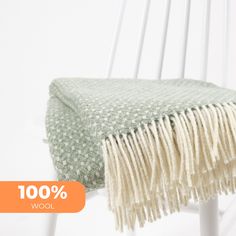 a green and white blanket sitting on top of a chair next to an orange tag