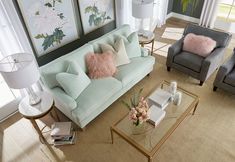 a living room with two couches, chairs and a coffee table in front of windows