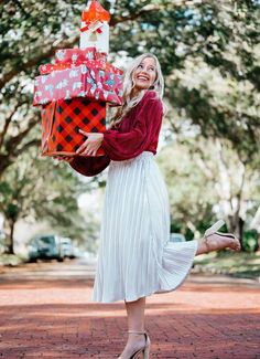 a woman in a white dress is holding presents