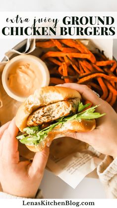 a person holding a chicken burger with lettuce and carrots