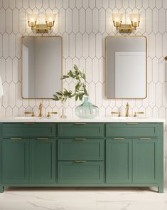 a bathroom with two sinks and mirrors on the wall next to each other in gold fixtures