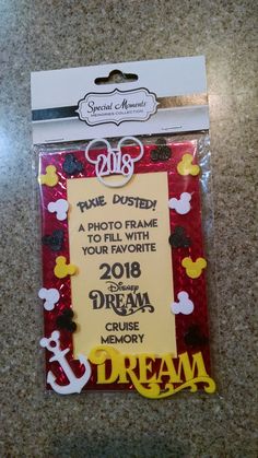 a photo frame with the words dream and mickey mouse on it, in front of a card