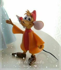 a figurine of a mouse wearing an orange dress