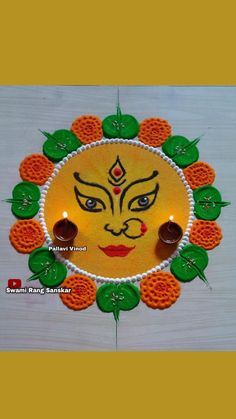 the face is made out of paper and decorated with oranges, leaves and candles